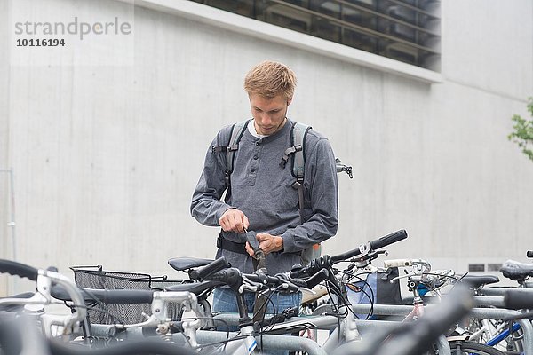 Mittlerer Erwachsener mit Schlüssel zum Verriegeln  Entriegeln des Fahrradschlosses  Blick nach unten