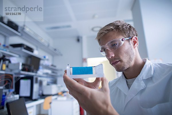 Junge männliche Wissenschaftlerin bereitet Experiment im Labor vor