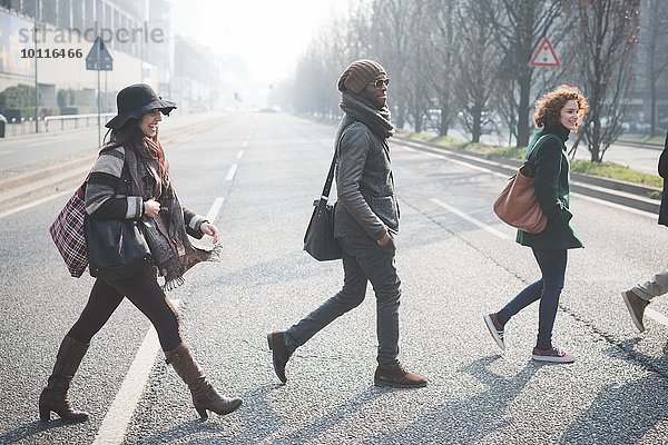 Vier junge Erwachsene überqueren die Stadtstraße