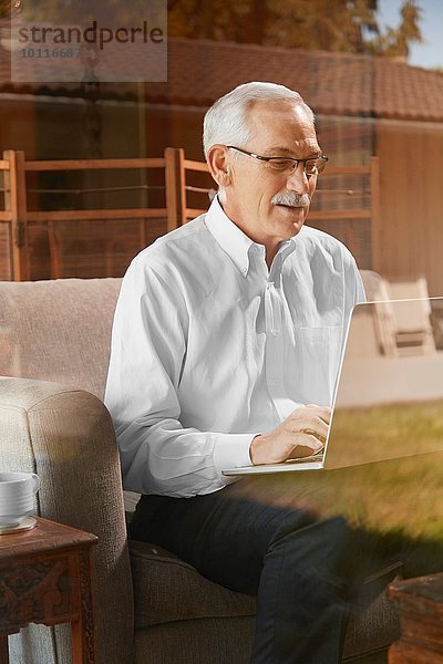 Senior Mann zu Hause  mit Laptop