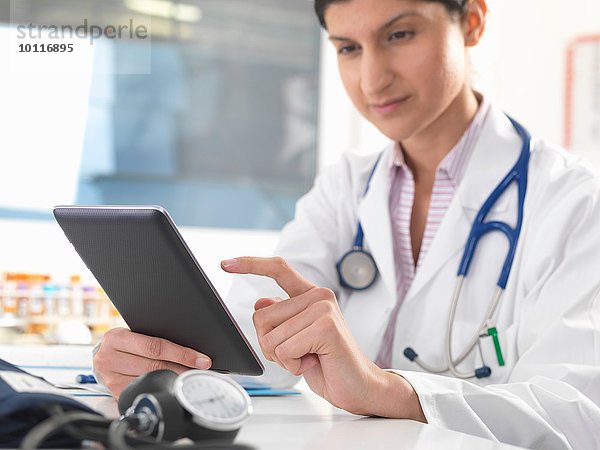 Ärztin aktualisiert Krankenakten auf digitalem Tablett