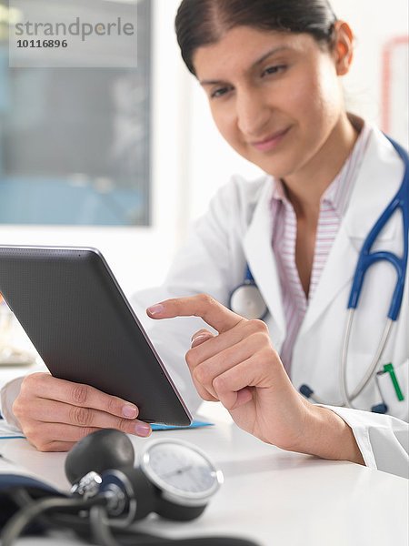 Ärztin aktualisiert Krankenakten mit Hilfe eines digitalen Tabletts