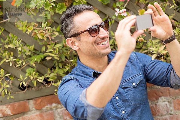 Mittlerer Erwachsener Mann  im Freien  Selbstporträt mit Smartphone