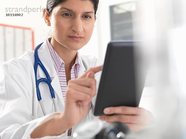 Ärztin mit digitalem Tablett-Touchscreen für Krankenakten