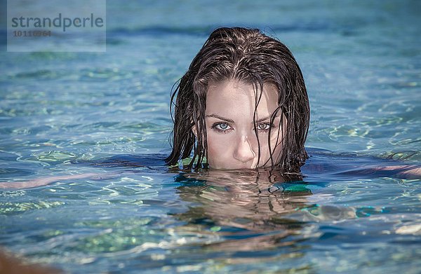 Porträt einer schönen jungen Frau mit im Meer versunkenem Gesicht