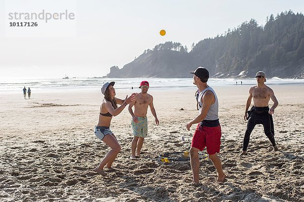 Vier erwachsene Freunde spielen mit Ball am Short Sands Beach  Oregon  USA