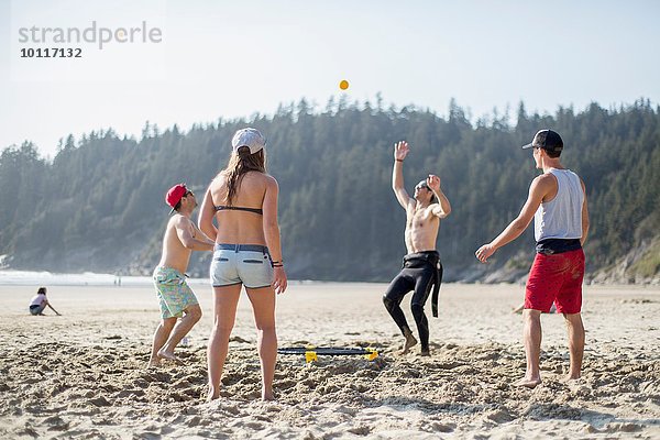 Vier erwachsene Freunde werfen und fangen Ball am Short Sands Beach  Oregon  USA