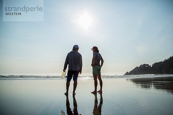 Rückansicht von zwei jungen Männern am Short Sands Beach  Oregon  USA