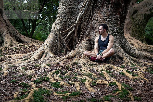 Junger Mann im Park Baumwurzeln  Sao Paulo  Brasilien