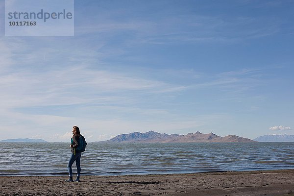 Rückansicht einer jungen Frau  die am Rande des Wassers steht  Great Salt Lake  Utah  USA
