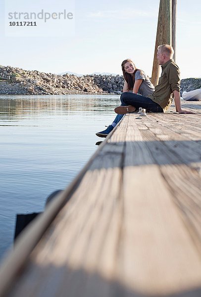 Seitenansicht eines jungen Paares auf einem hölzernen Pier im Gespräch  Great Salt Lake  Utah  USA