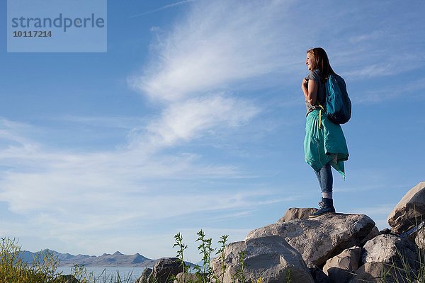 Rückansicht einer jungen Frau mit Rucksack auf Felsen stehend  Great Salt Lake  Utah  USA