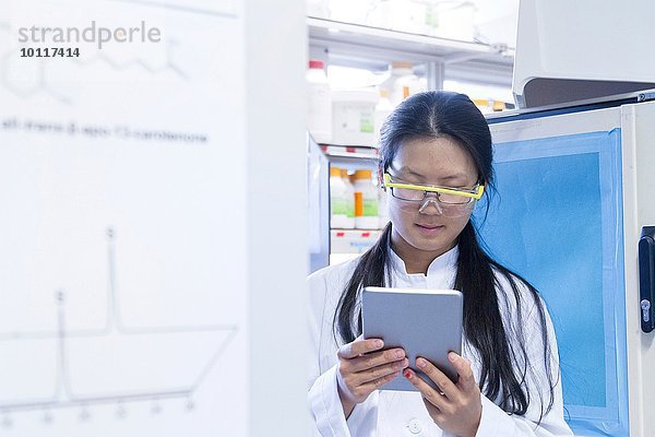 Wissenschaftlerin beim Lesen von digitalen Tabletten im Labor