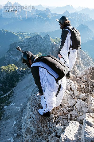 Zwei männliche BASE-Springer beim Start vom Berg  Dolomiten  Italien