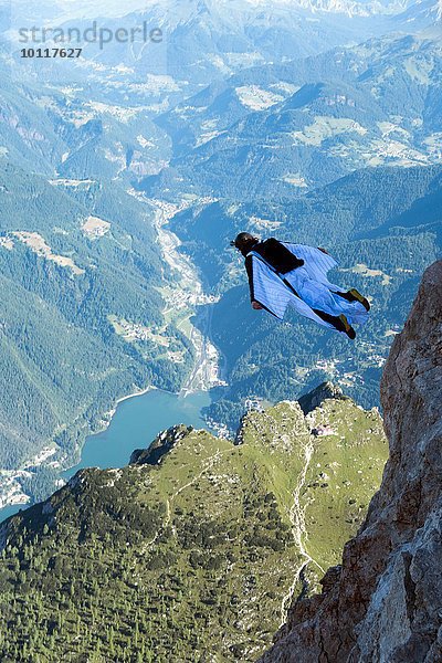 Männlicher BASE Jumper Wingsuit über dem Tal  Dolomiten  Italien