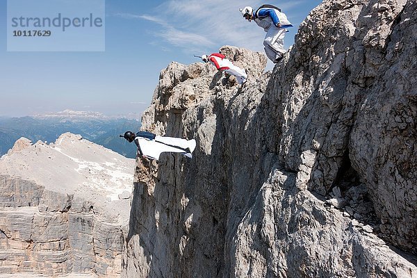 Drei männliche BASE-Springer  die von der Bergspitze aussteigen  Dolomiten  Italien