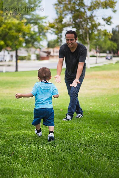 Junger Mann spielt mit Kleinkindbruder im Park