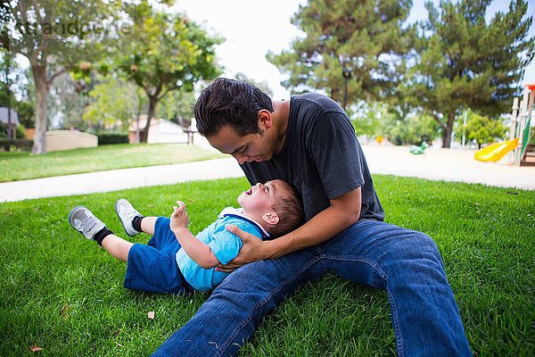 Männliches Kleinkind beim Spielen mit dem älteren erwachsenen Bruder im Park