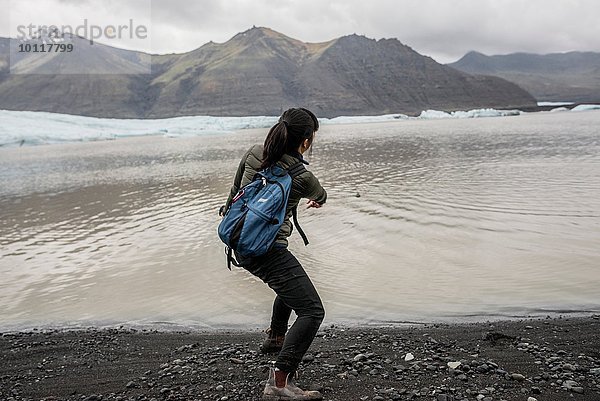 Rückansicht der weiblichen Touristenabschaumsteine im Meer  Skaftafell  Island