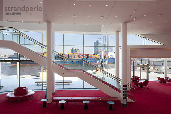 Treppe zwischen den Foyer-Ebenen mit Blick auf ein Containerschiff vor der Stadt mit der Elbphilharmonie  Stage Theater an der Elbe  Hamburg  Deutschland  Europa