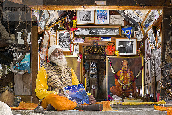 Swami Sundaranand  ein berühmter Sadhu  Yogi und Fotograf  sitzt vor seinem Haus mit seinem Buch  Gangotri  Uttarakhand  Indien  Asien
