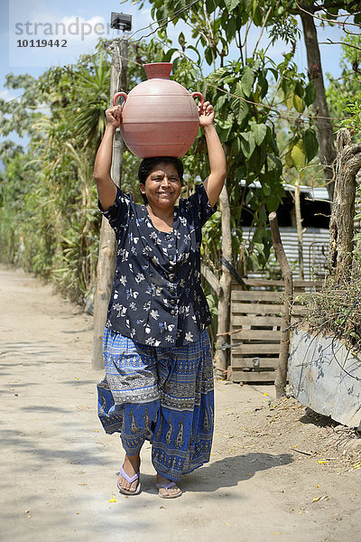 Frau trägt Wasser in einem Krug auf dem Kopf  Armensiedlung Colonia Monsenor Romero  Distrito Itália  San Salvador  El Salvador  Nordamerika