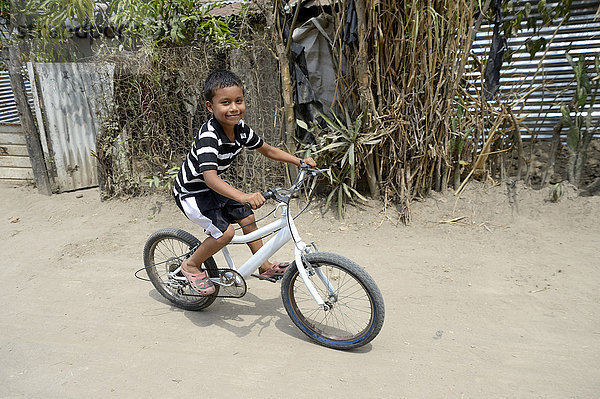 Junge fährt mit dem Fahrrad  Friedensinitiative von Polizei und katholischer Kirche im Armenviertel Colonia Monsenor Romero  Distrito Itália  San Salvador  El Salvador  Nordamerika