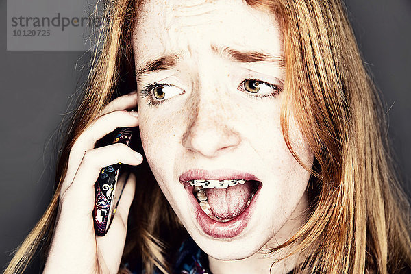 Teenager telefoniert mit einem Smartphone und schaut überrascht