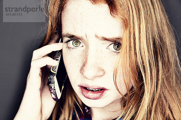 Teenager telefoniert mit einem Smartphone und schaut genervt