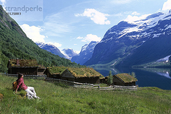 Frau vor alten Häusern am Loensee am Nordfjord  Norwegen  Skandinavien  Europa