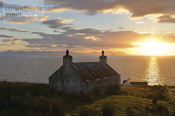 Abendlicher Ausblick kurz vor Sonnenuntergang auf die Insel Skye auf einer Singletrackroad mit altem schottischem Steinhaus  Melvaig  Gairloch  Western Ross  Schottland  Vereinigtes Königreich