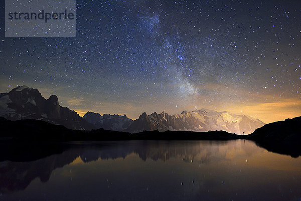 Mont Blanc Massiv bei Nacht mit Milchstraße  spiegelt sich im Lac de Chésserys  links Aiguilles de Chamonix  rechts Mont Blanc  Chamonix  Frankreich  Europa