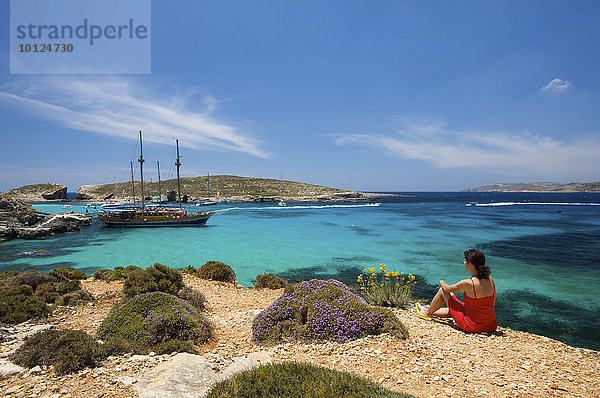 Frau blickt auf Ausflugsschiffe in der Blauen Lagune von Comino  Malta  Europa