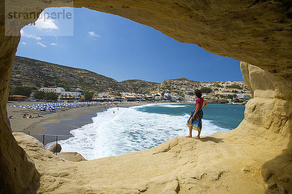 Frau steht vor Höhle am Strand von Matala  Kreta  Griechenland  Europa