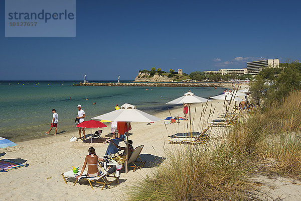 Urlauber mit Sonnenschirmen am Strand von Sani  Kassandra  Chalkidiki  Griechenland  Europa