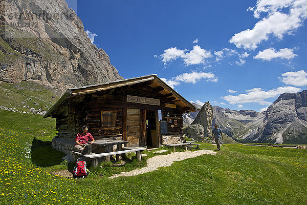 Frau macht Rast auf der Malga Alm unterhalb der Geislerspitzen  Seceda  Grödnertal  Dolomiten  Provinz Südtirol  Trentino-Südtirol  Italien  Europa