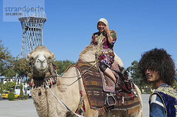 Einheimische Touristin auf Kamel vor der Zitadelle Ark  Buchara  Usbekistan  Asien