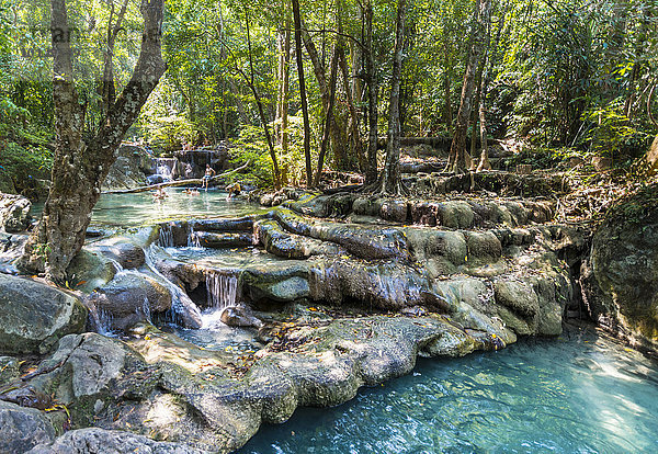 Touristen baden in einem Wasserfall im Erawan-Nationalpark  Provinz Kanchanaburi  Thailand  Asien