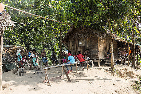 Menschen sitzen vor Holzhütten  Volksstamm Orang Asil  Ureinwohner  indigenes Volk  Nationalpark Taman Negara  Malaysia  Asien