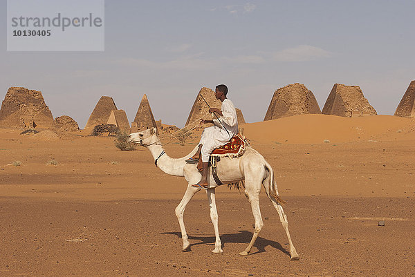 Einheimischer reitet auf Dromedar vor Pyramiden des Nordfriedhofs von Meroë  nubische Wüste  Nubien  Nahr an-Nil  Sudan  Afrika