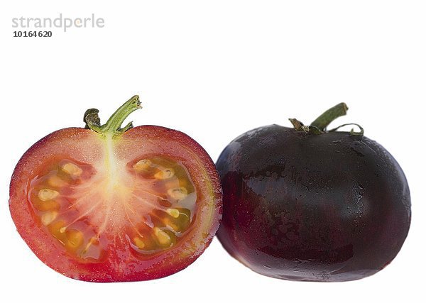 'Schwarze Tomate ''Indigo Rose''  halbiert und ganz'