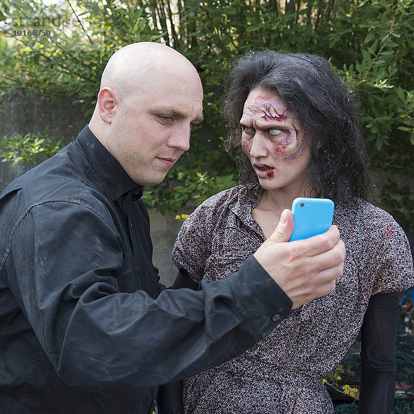 Zombie und Mann mit Smartphone  Filmdreh  Szene aus Zombiekomödie  Kurzfilm Brain Freeze