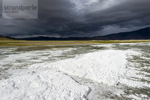 Salzschichten  karge Landschaft und dunkle Wolken am Tso Kar  Weißer See  ein stark schwankender Salzsee  4530 m  Changtang Region  Thukje  Jammu und Kaschmir  Indien  Asien