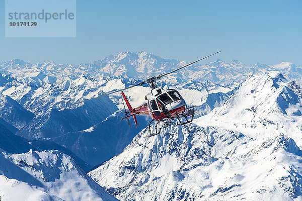 Helikopter im Flug vor Bergpanorama im Winter  Schweizer Alpen  Engadin  Graubünden  Schweiz  Europa