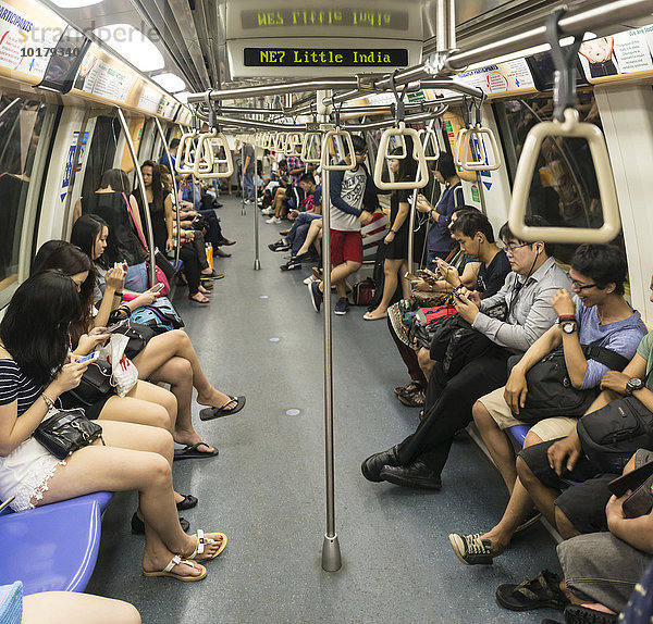 Asiatische Menschen sitzen in einer U-Bahn  Station Little India  Singapur  Asien