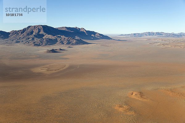 Luftbild aus einem Heißluftballon  Wüstenebenen mit sogenannten Feenkreisen und isolierten Bergrücken am Rande der Namib-Wüste  NamibRand-Naturreservat  Namibia  Afrika