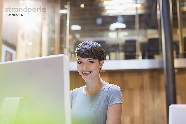 Portrait lächelnde Geschäftsfrau bei der Arbeit am Computer im Büro