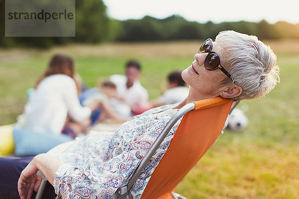 Seniorin entspannt sich im Stuhl im Feld