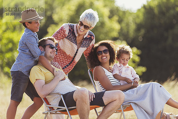 Mehrgenerationen-Familie entspannt im sonnigen Feld