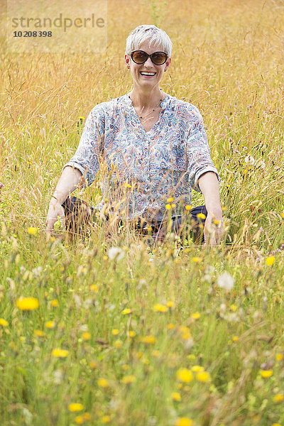Portrait Seniorin im Schneidersitz im ländlichen Raum